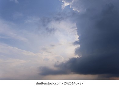 This photo shows a view of a slightly cloudy sky with white clouds covering part of the sky. The sky was dark blue with fluffy, wispy white clouds. The slightly dim sunlight illuminated the entire sce