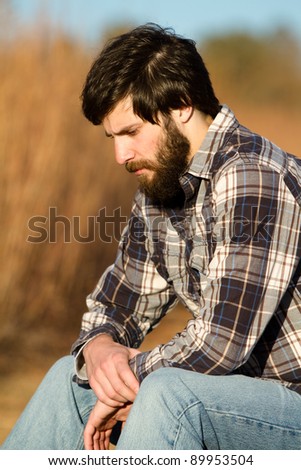 Similar – Man sitting by the river in fall