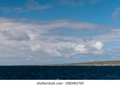 This photograph captures both PMV Plassey (or Plassy) shipwreck and Lighthouse on the coast of Inisheer.   The view is looking southwest from the Doolin Ferry, Aran Islands, County Galway, Ireland.