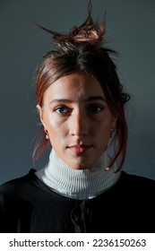 This photograph is a portrait of young woman with low key side lighting