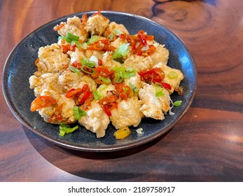 This is a picture of Crispy Salt and Pepper Tofu. Fried Crispy Tofu sautéed with salt, white pepper, garlic, onions, green onions, and some chilies for extra spice.  - Shutterstock ID 2189758917