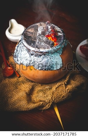 This picture portrayed traditional Pakistani, Indian food in very beautiful, appealing way. The pot can have multiple type of dishes in it for eg. Biryani, Qorma, Gosht etc. It is mouthwatering rice.
