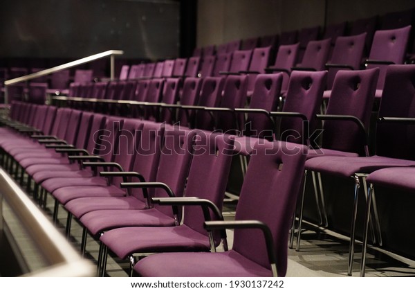 this picture shows purple chairs in a theater. no people
are visible. the chairs have armrests and form a beautiful pattern.
