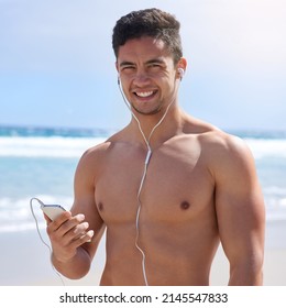 This Playlist Gets Me Going. Portrait Of A Handsome Young Man Setting Up His Workout Playlist On The Beach.