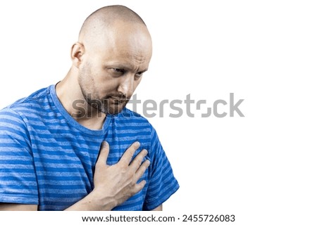 This powerful image portrays a man in the throes of chest pain, his hand tightly clutching his chest. His casual attire of a blue and white striped t-shirt adds a sense of normalcy to the scene