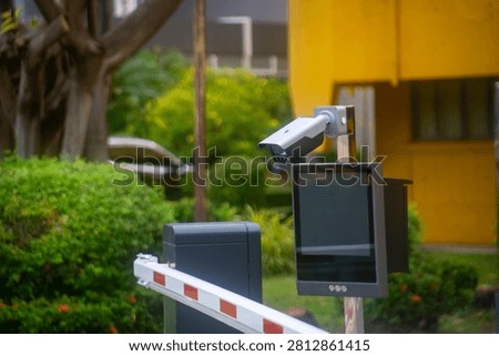 This security system features an outdoor monitor and barrier gate setup used at parking lot entrances for vehicle access control and safety management.