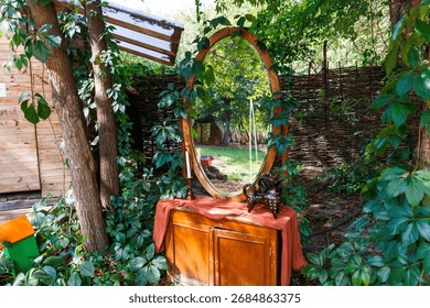 This serene image captures a rustic mirror nestled among trees and greenery, accompanied by a small table and decorative elements, creating a peaceful outdoor setting.