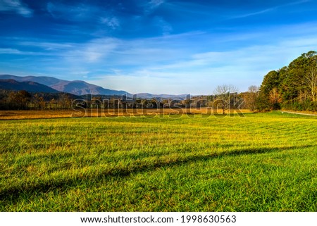 This shot to the west shows the Cades Cove just after sunrise in late October.  The grass is green and the skies are a beautiful slate blue with just enough clouds to add some interest.  