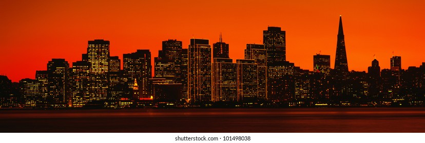 This Is The Skyline Of San Francisco At Sunset. There Is An Orange Glow In The Sky.