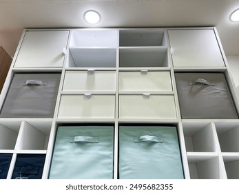 This sleek vertical shelf, complete with colorful bins, provides an elegant and highly functional solution for efficiently organizing any modern home or office space in a stylish manner
