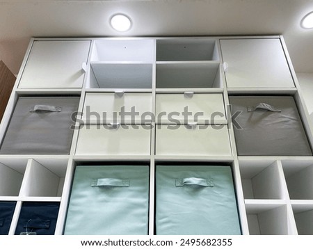 This sleek vertical shelf, complete with colorful bins, provides an elegant and highly functional solution for efficiently organizing any modern home or office space in a stylish manner