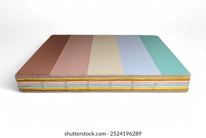 This is a small notebook with stacked horizontal layers in various pastel colors: brown, pink, beige, yellow, blue, and green. - Powered by Shutterstock