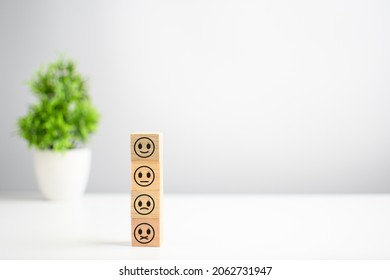 This smiley face wood cube happy smiley face icon gives satisfaction in service. rating very impressed. Customer service and Satisfaction concept. Copy space on right for design, text, Selective focus