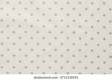 This soft fabric features a repeating pattern of gray polka dots on a cream background, perfect for various design projects