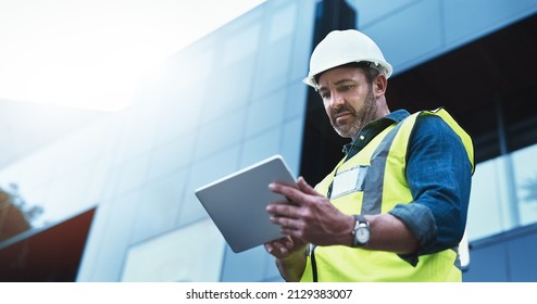 This software help me to keep track of everything. Shot of a engineer using a digital tablet on a construction site. - Powered by Shutterstock