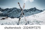This striking image captures the essence of winter sports with a pair of skis forming a perfect X in fresh powder snow.