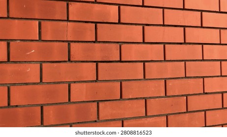 This structure showcases a red brick wall with a uniform layout, highlighting the intricacies of masonry work and adding a touch of warmth to the architecture.