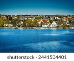 This stunning photo captures the picturesque town of Delecke situated on the shores of Lake Möhne in North Rhine-Westphalia. In the foreground, the blue waters of the lake stretch out