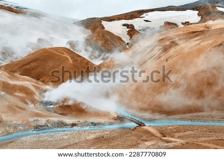 This stunning photo of Iceland's Landmannalaugar region captures the raw, untamed beauty of the area, with its striking rhyolite mountains, active volcano, and vibrant colors