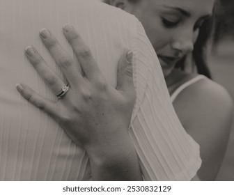 This timeless image captures the deep connection of a bride and groom on their wedding day. It emphasizes the commitment of the engagement ring, and a soft smile on the bride's face.