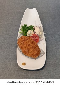 This is Tonkatsu pork. It is a Japanese food menu. It is served with vegetable salad, mashed potatoes, and Tonkatsu sauce.