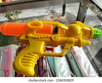 This Is A Toy Water Gun Made Of Plastic That Is Placed On A Glass Table
