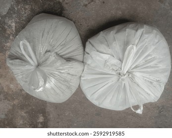 This type of packaging is commonly used for construction materials, waste disposal, or storage of bulk items. The scene suggests an industrial, construction,