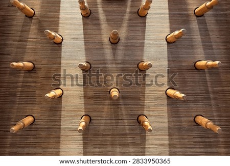 This unique wall installation features numerous wooden rolling pins protruding horizontally from a slatted timber background. The repetitive pattern and warm wood tones create a textured, sculptural effect that blends culinary utility with modern interior design. It serves as a creative, eye-catching feature wall perfect for a bakery or restaurant.