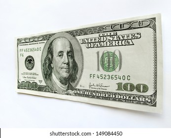 This United States One Hundred Dollar Bill with a portrait of Benjamin Franklin stands vertically isolated against a white backdrop with perspective focus on the dollar amount.