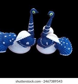 This vibrant and imaginative craft transforms ordinary seashells into a stunning peacock masterpiece. Each shell is meticulously arranged and painted in a spectrum of iridescent colors,