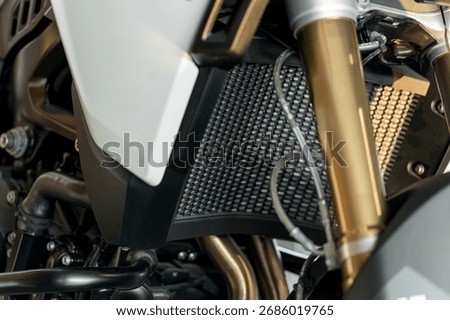This view highlights the radiator and engine parts of a motorcycle, focusing on their structure, texture, and the materials used for cooling.
