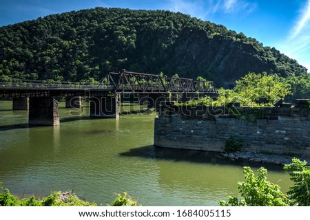 This is a view from The Point in Harper's Ferry, West Virginia, showing an old railroad bridge, the footbridge that goes to the C & O Canal, and where the Shenandoah meets the Potomac River.