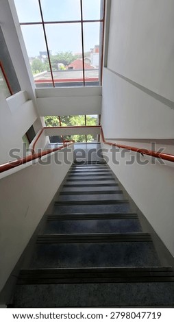 This visual work emphasizes the architectural elegance of staircases, captured from an elevated, downward-facing perspective. It explores the interplay of line, geometry, and depth to construct a compelling spatial illusion that engages the viewer’s perception.