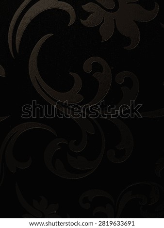 This wallpaper features a black damask or floral pattern with glossy details.
