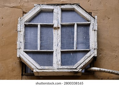 This weathered octagonal window silently records the exquisite craftsmanship of early master artisans. Set within a faded, time-worn frame, its intricate geometric design showcases the artistic dedication of a bygone era. It serves as a beautiful architectural relic, beautifully preserving a quiet piece of Taiwan’s rich cultural history.