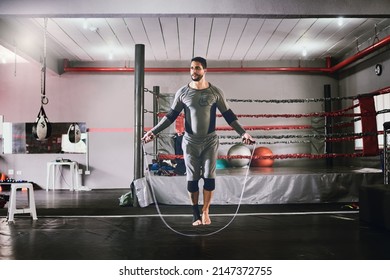 This is what I do before every session. Shot of a focused young male boxer using a skipping rope for training exercises inside of a gym during the day. - Powered by Shutterstock