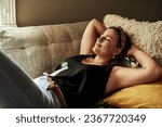 This is why weekends were invented. Shot of a young woman relaxing on the sofa at home.