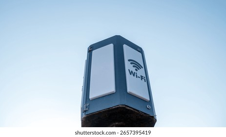 This wireless internet access point stands prominently against a clear sky, showcasing connectivity technology in an urban environment during late afternoon.