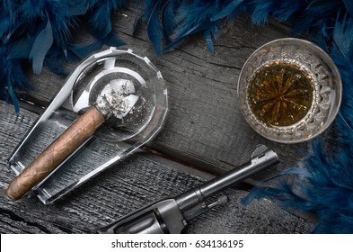 Thompson Gun, Revolver, Cigar On Ashtray, Whiskey Glass And Blue Feather Boa