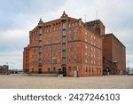 Thormann Speicher, historic granary building of red brick at the old harbor in Wismar, Germany, the heritage-listed landmark is now renovated for gastronomy and offices, gray overcast sky, copy space