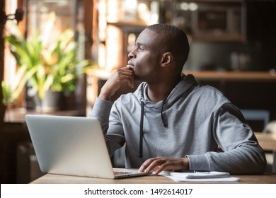 Thoughtful african american businessman lost in thoughts search for inspiration sit at cafe table using laptop, dreamy pensive contemplative black student looking away thinking of new creative ideas - Powered by Shutterstock