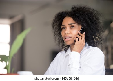 Thoughtful African American woman talk over phone looking in distance considering idea, pensive black female have cell conversation thinking of problem solution, being serious making decision