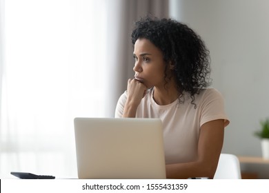 Thoughtful African American woman using laptop, pondering task or strategy, looking in distance, student freelancer working on difficult project at home, pensive girl taking break, planning - Shutterstock ID 1555431359