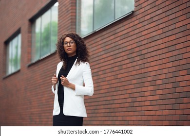 Thoughtful. African-american businesswoman in office attire smiling, looks confident and serious, busy. Finance, business, equality and human rights concept. Beautiful young model, successful.