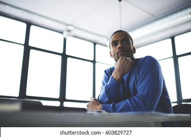Thoughtful afro american young artist inspiring observing from interior and strangers passing him by planning to create painting while sitting in cafeteria waiting for meeting with colleagues - Shutterstock ID 603829727