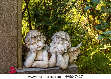 Thoughtful angel couple figures on a Stone wall
