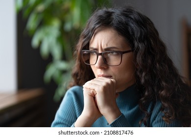 Thoughtful anxious italian business woman looking away think, try to solve problem at work. Worried serious millennial woman in eyeglasses concerned make difficult decision, waiting for exam results - Shutterstock ID 2108817476
