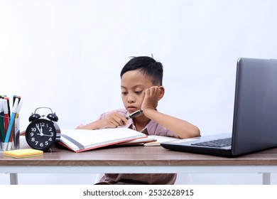 Thoughtful Asian schoolboy studying in the classroom. Isolated on white background - Powered by Shutterstock