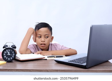 Thoughtful Asian schoolboy studying in the classroom. Isolated on white background - Powered by Shutterstock