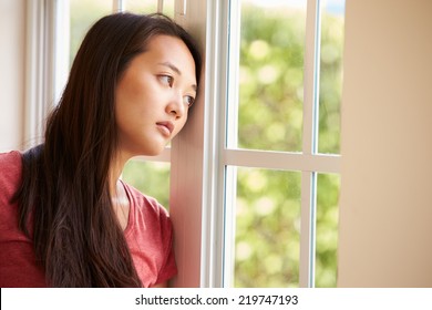 Thoughtful Asian Woman Looking Out Of Window